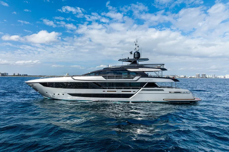 Slide: The Image of 2024 Riva 130' Bellissima yacht cruising on open water under a blue sky. - 2