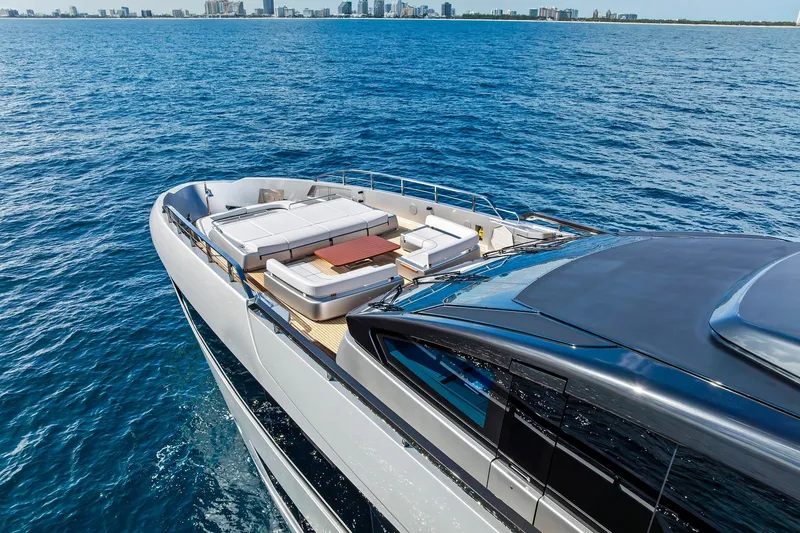 Slide: The Image of Luxurious 2024 Riva 130' Bellissima yacht cruising on open sea with city skyline backdrop. - 6