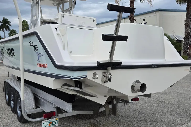 Slide: The Image of 2005 SeaVee 310i Open boat on trailer, featuring Yanmar branding and rear ladder. - 2
