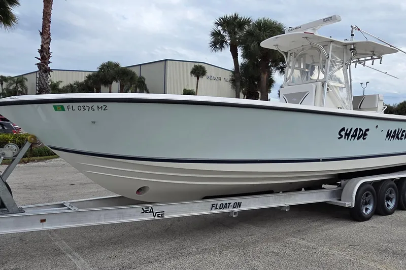 Slide: The Image of 2005 SeaVee 310i Open boat on trailer, parked outdoors with palm trees. - 3