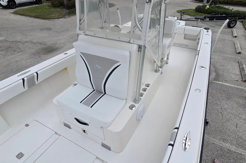 Slide: The Image of 2005 SeaVee 310i Open boat with white seating and console, parked on pavement. - 31