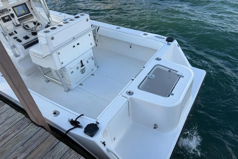 Slide: The Image of 2005 SeaVee 310i Open boat interior with helm and storage, docked by the water. - 46