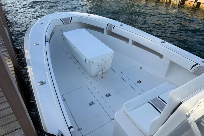Slide: The Image of 2005 SeaVee 310i Open boat interior with seating and storage, docked by the water. - 49