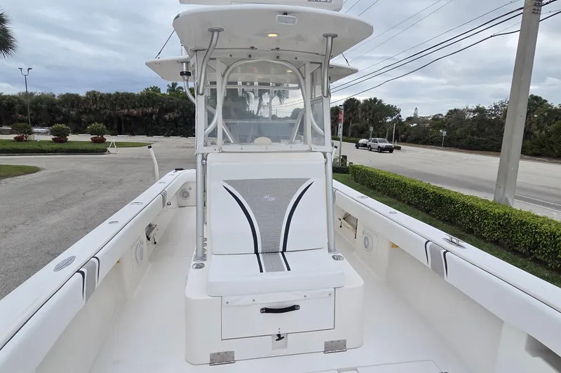 Slide: The Image of 2005 SeaVee 310i Open boat with sleek white deck and seating, parked roadside. - 9