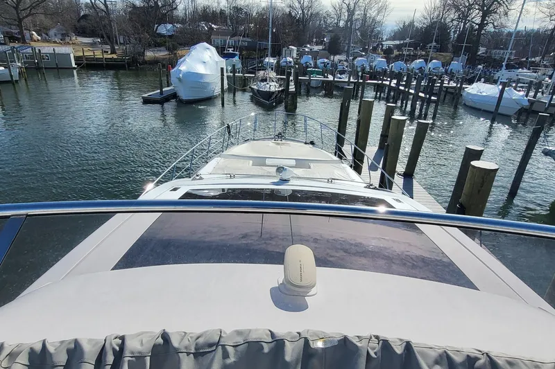 Slide: The Image of 2023 Azimut S7 yacht docked in a marina with surrounding boats. - 11