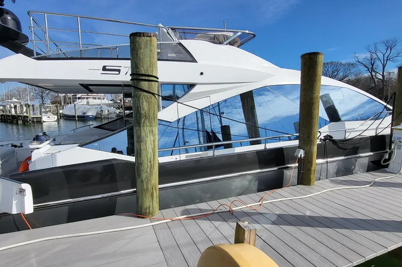 Slide: The Image of 2023 Azimut S7 yacht docked at marina, sleek design, sunny day. - 14