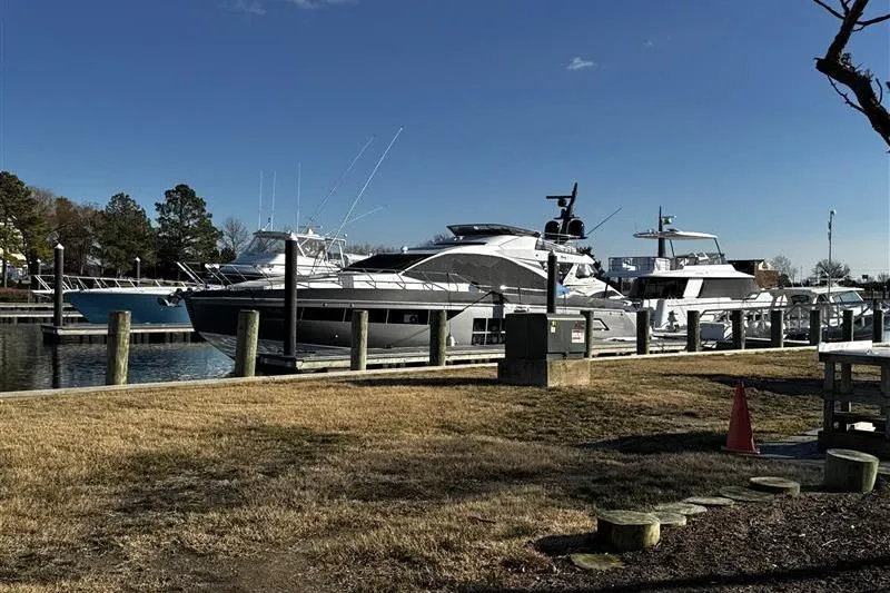 Slide: The Image of 2023 Azimut S7 yacht docked at a marina under clear blue skies. - 2