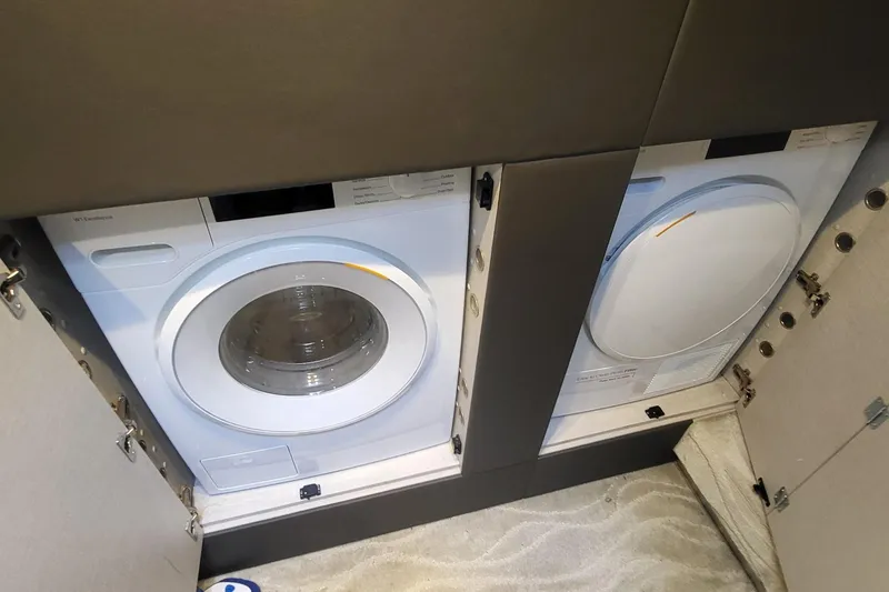 Slide: The Image of Laundry appliances in 2023 Azimut S7 yacht interior, featuring washer and dryer units. - 33