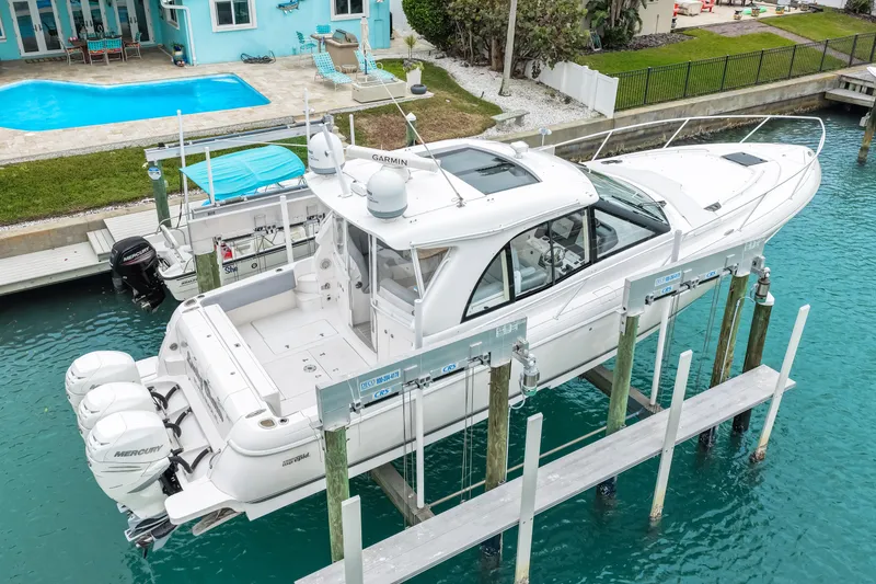 Slide: The Image of 2019 Intrepid 410 Evolution yacht docked near a waterfront home with pool. - 12