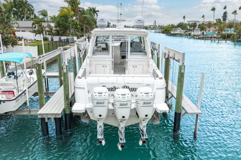 Slide: The Image of 2019 Intrepid 410 Evolution boat docked with triple 350 engines, surrounded by clear blue water. - 13
