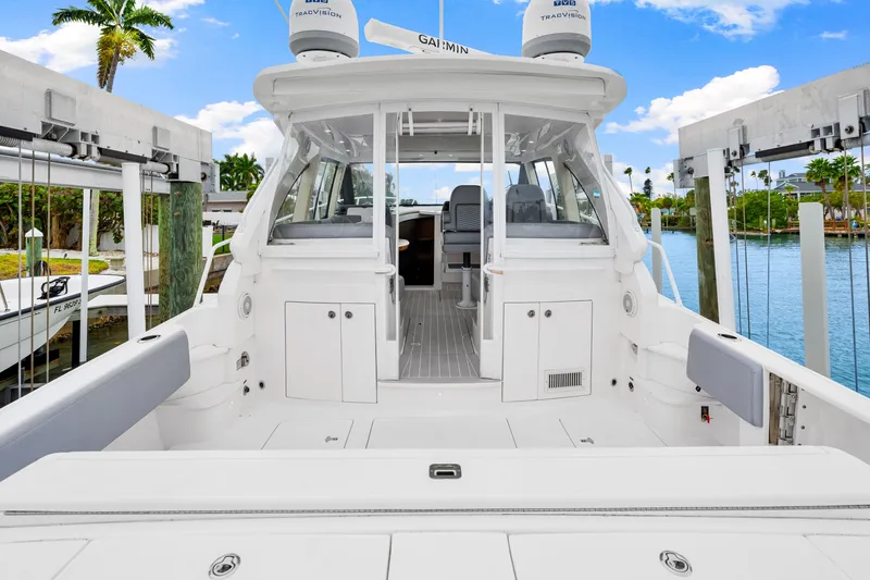 Slide: The Image of 2019 Intrepid 410 Evolution yacht docked, showcasing spacious deck and sleek design. - 23
