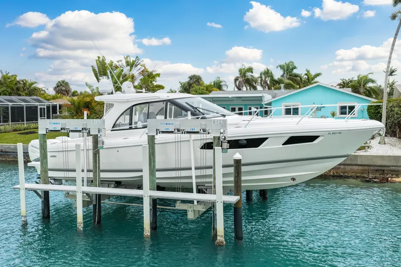 Slide: The Image of 2019 Intrepid 410 Evolution yacht docked in a scenic waterfront setting. - 3