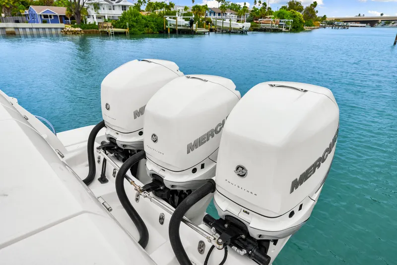 Slide: The Image of 2019 Intrepid 410 Evolution with triple Mercury outboard engines on a serene waterfront. - 30