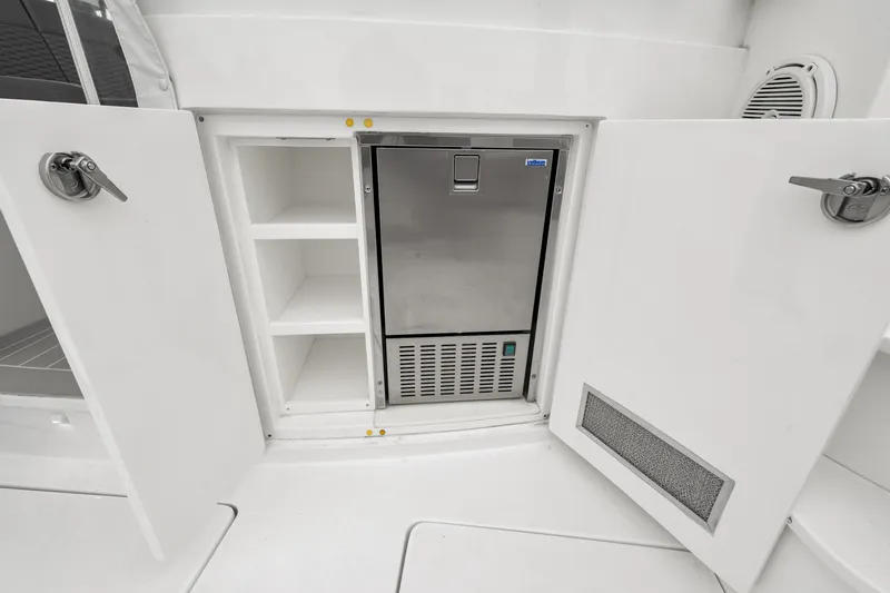 Slide: The Image of 2019 Intrepid 410 Evolution yacht interior with storage and stainless steel fridge. - 32