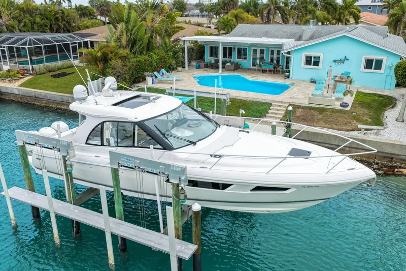 Slide: The Image of 2019 Intrepid 410 Evolution yacht docked by a waterfront home with pool. - 5