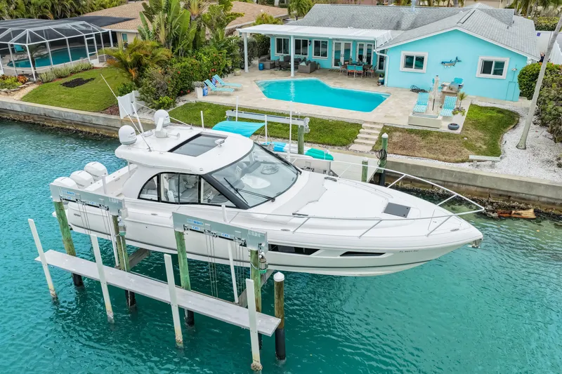 Slide: The Image of 2019 Intrepid 410 Evolution yacht docked by a waterfront home with pool. - 6