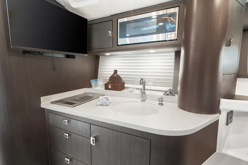 Slide: The Image of Modern kitchen area in 2019 Intrepid 410 Evolution yacht with sleek cabinetry and appliances. - 62