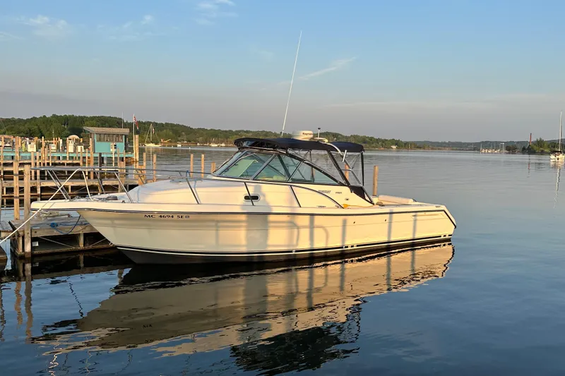 The Image of 2003 Pursuit 2865 Denali boat docked on calm water at sunset. - 0