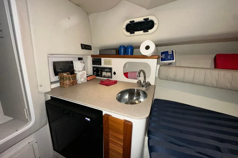 Slide: The Image of Compact galley in 2003 Pursuit 2865 Denali boat with sink, microwave, and storage. - 16