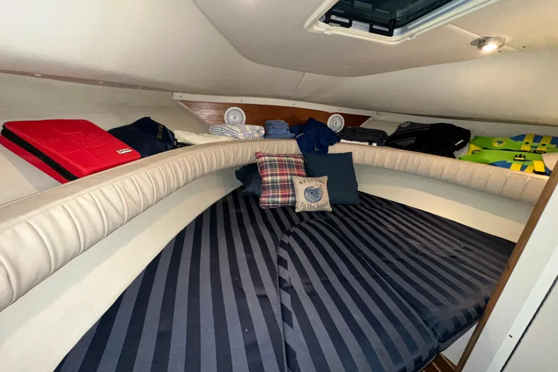 Slide: The Image of Cozy cabin interior of 2003 Pursuit 2865 Denali boat with striped bedding and cushions. - 17