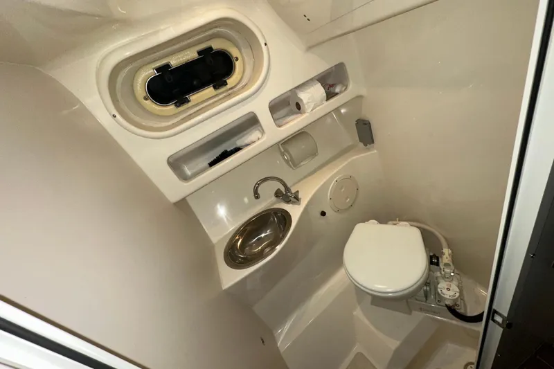 Slide: The Image of Compact bathroom in 2003 Pursuit 2865 Denali boat with sink and toilet. - 18