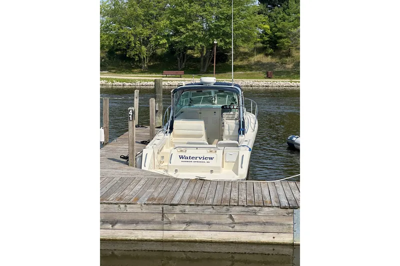 Slide: The Image of 2003 Pursuit 2865 Denali boat docked at a serene lakeside pier. - 3