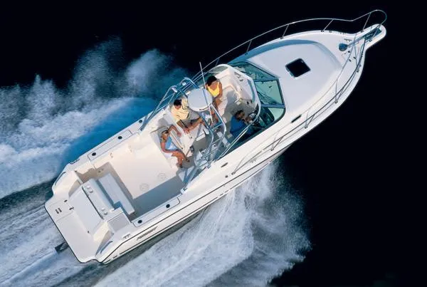 Slide: The Image of 2003 Pursuit 2865 Denali boat interior with seating and helm, under a dark canopy. - 7