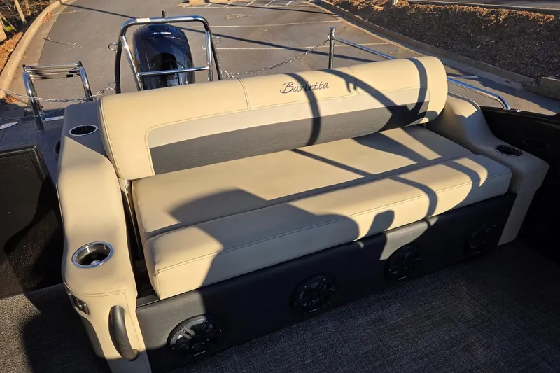 Slide: The Image of 2020 Barletta C22UC boat with beige seating and cup holders, parked outdoors. - 13