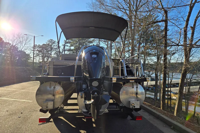 Slide: The Image of 2020 Barletta C22UC pontoon boat parked near a lake, surrounded by trees. - 4