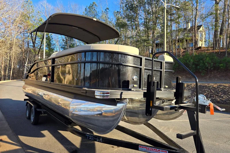 Slide: The Image of 2020 Barletta C22UC pontoon boat on trailer, parked near wooded area. - 6
