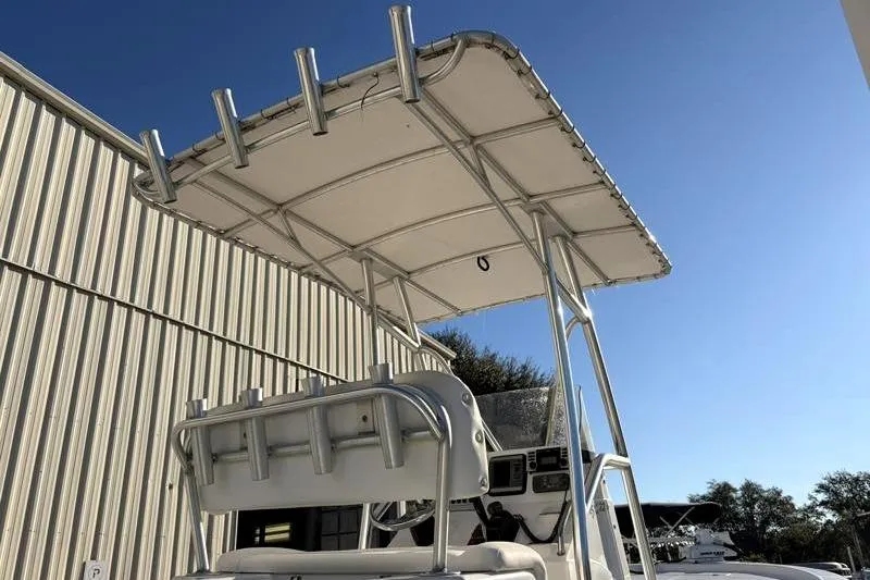 Slide: The Image of 2011 Sea Hunt BX 22 BR boat with T-top and rod holders, parked outdoors. - 14