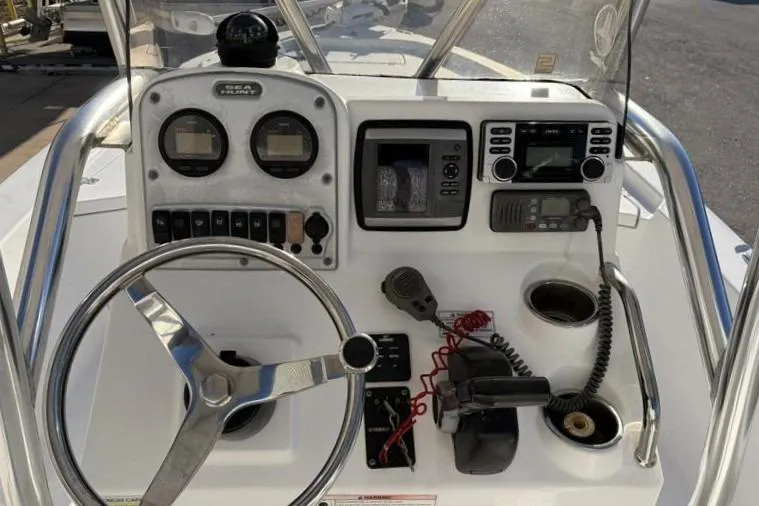 Slide: The Image of 2011 Sea Hunt BX 22 BR boat dashboard with steering wheel and navigation instruments. - 26