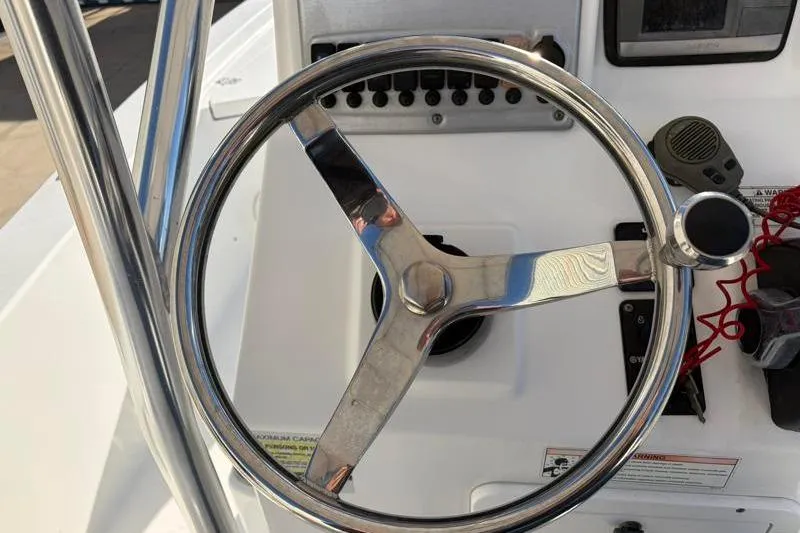 Slide: The Image of Steering wheel of a 2011 Sea Hunt BX 22 BR boat, featuring control panel and radio. - 30