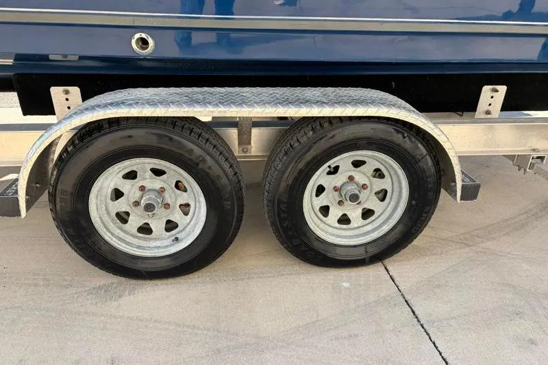 Slide: The Image of Trailer wheels of a 2011 Sea Hunt BX 22 BR boat on pavement. - 37
