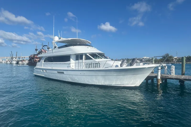 The Image of 2000 Hatteras 75 Sport Deck Motor Yacht docked in clear blue water. - 0