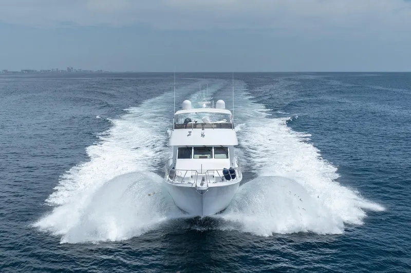 Slide: The Image of Hatteras 75 Sport Deck Motor Yacht 2000 cruising on open sea, creating dynamic water wake. - 15