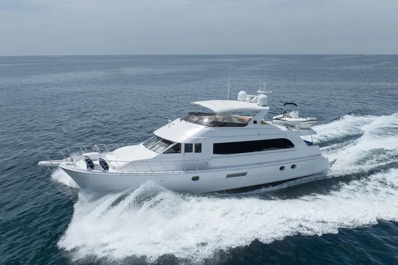 Slide: The Image of 2000 Hatteras 75 Sport Deck Motor Yacht cruising on open water. - 10