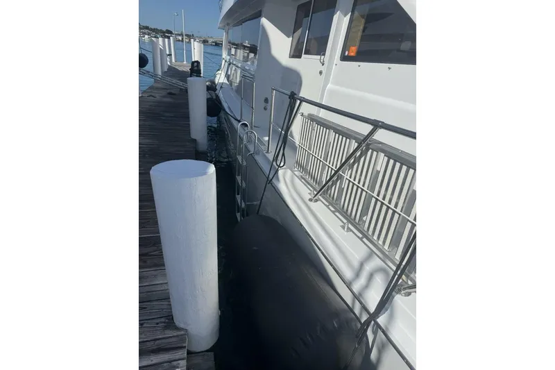 Slide: The Image of Hatteras 75 Sport Deck Motor Yacht 2000 docked at marina with fender protection. - 20