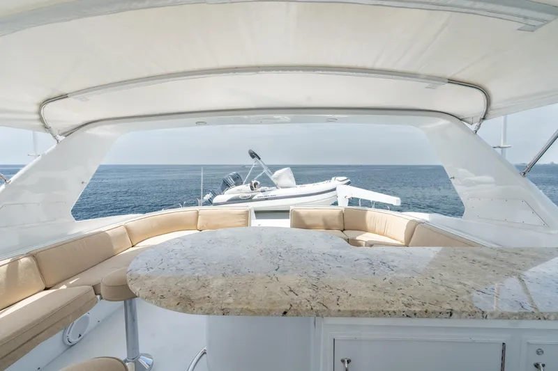 Slide: The Image of Luxurious 2000 Hatteras 75 Sport Deck Motor Yacht with elegant seating and ocean view. - 28