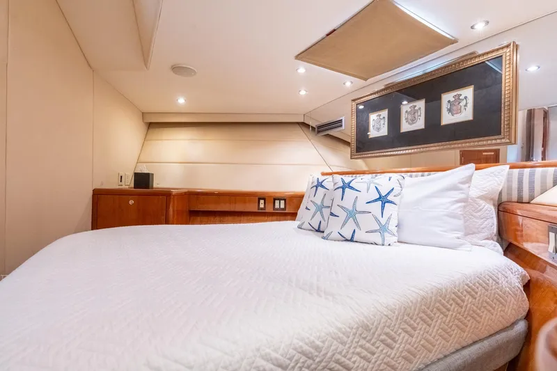 Slide: The Image of Luxurious bedroom interior of 2000 Hatteras 75 Sport Deck Motor Yacht with starfish-themed pillows. - 63