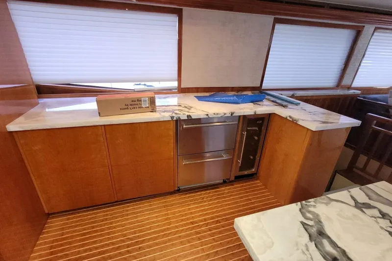 Slide: The Image of Interior of 2000 Hatteras 75 Sport Deck Motor Yacht with marble countertops and wooden cabinetry. - 5