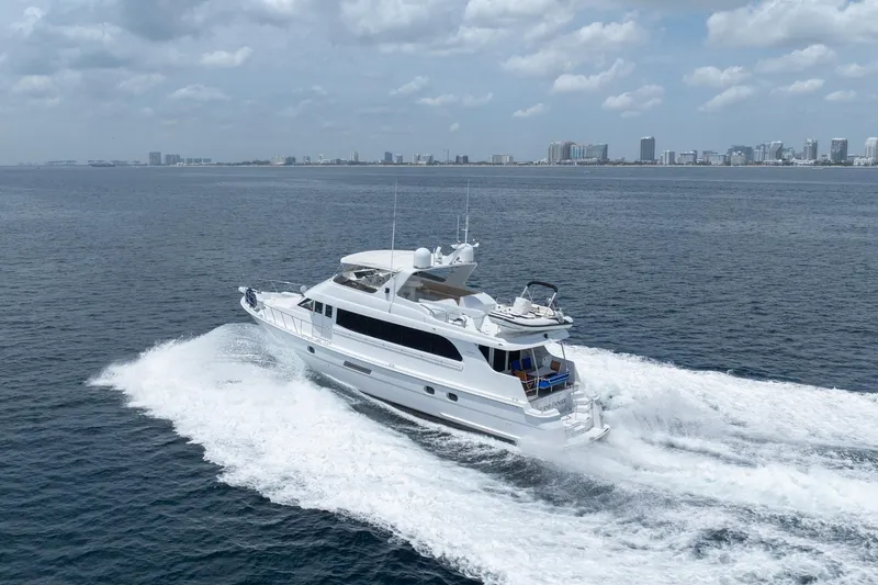 Slide: The Image of Luxury 2000 Hatteras 75 Sport Deck Motor Yacht cruising on open water. - 13