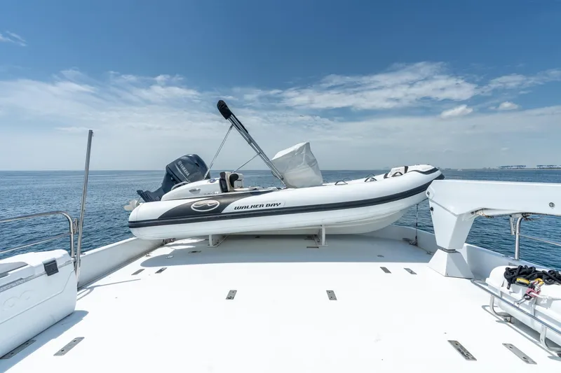 Slide: The Image of 2000 Hatteras 75 Sport Deck Motor Yacht with dinghy on deck, ocean view. - 30