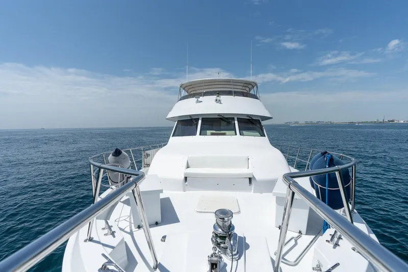 Slide: The Image of Hatteras 75 Sport Deck Motor Yacht 2000 cruising on open sea under clear sky. - 16