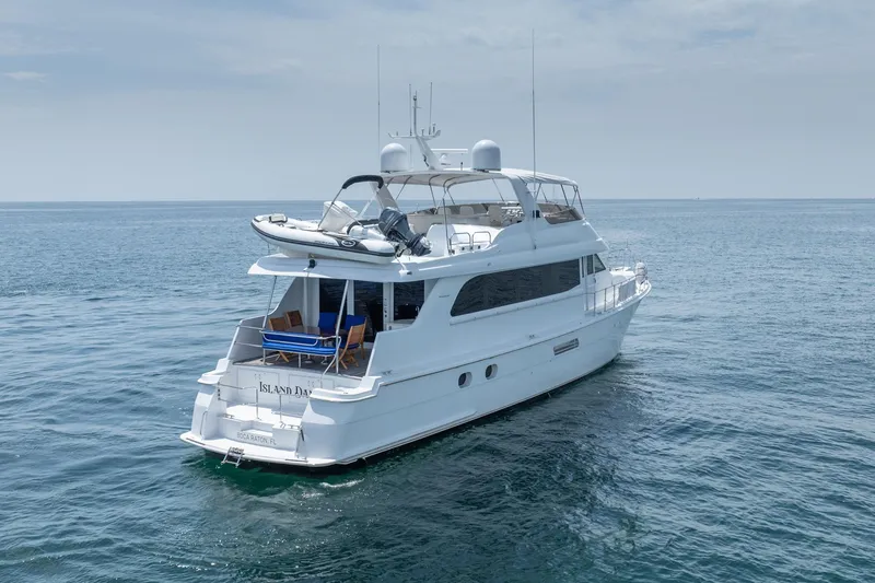 Slide: The Image of 2000 Hatteras 75 Sport Deck Motor Yacht on open water, featuring spacious deck and sleek design. - 7
