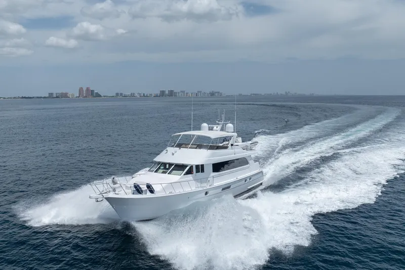 Slide: The Image of 2000 Hatteras 75 Sport Deck Motor Yacht cruising on open water. - 14
