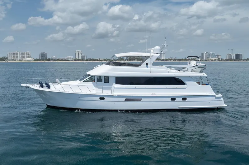Slide: The Image of 2000 Hatteras 75 Sport Deck Motor Yacht cruising on calm waters under a cloudy sky. - 5