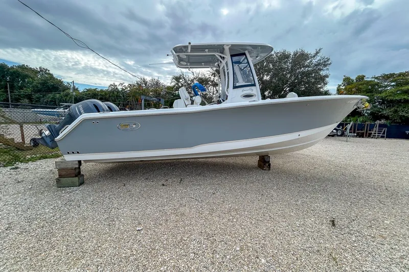 The Image of 2018 Sea Hunt Gamefish 27 boat on gravel, overcast sky background. - 1
