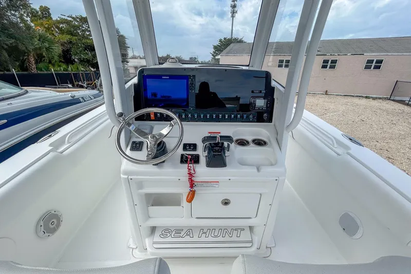 Slide: The Image of 2018 Sea Hunt Gamefish 27 boat console with steering wheel and navigation display. - 4
