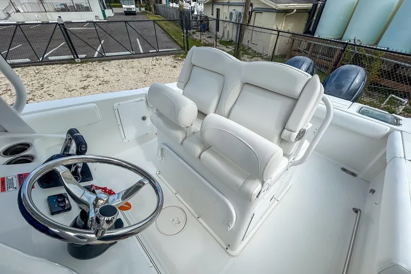 Slide: The Image of 2018 Sea Hunt Gamefish 27 boat cockpit with dual white captain's chairs and steering wheel. - 6